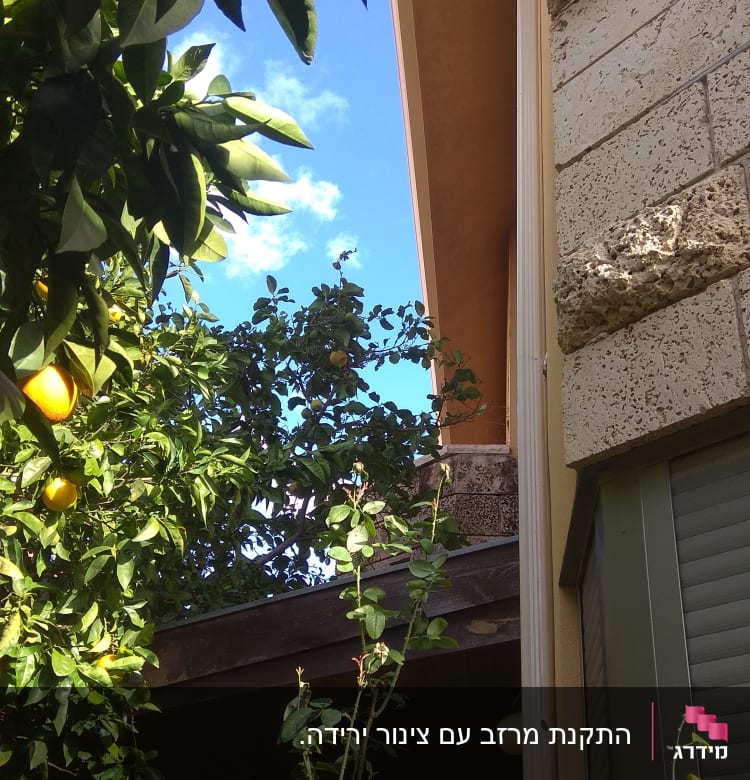 מרזב לבן מחובר לגג חום של בית